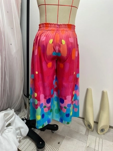 Detail of elastic high waistband on wide-leg trousers with colorful abstract art print