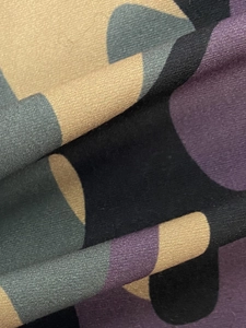 Macro shot of knit fabric texture featuring a multi-color camouflage pattern in khaki and purple