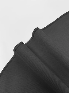 Macro close-up of high-quality black dress fabric showing precise hem stitching and texture