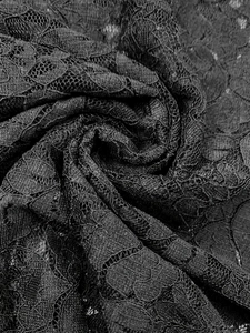 Close-up of black lace fabric with exquisite hollowed-out floral patterns and soft texture