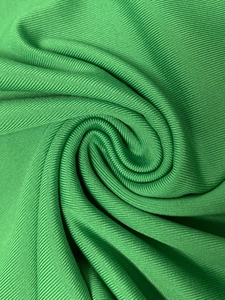 Vue macro du tissu en maille côtelée vert vif montrant la texture verticale et l'élasticité