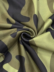 Macro texture detail of high-quality camouflage printed fabric with soft draping ripples