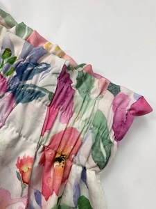 Detailed macro shot of floral print wide-leg trousers with elastic waistband texture