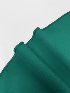 Detail of dark green dress showing breathable fabric texture and overlock sewing craft