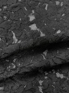 Close-up of black floral lace fabric with intricate hollow mesh and soft texture