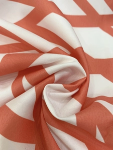 Close-up of orange and white zigzag geometric pattern on a soft textile fabric