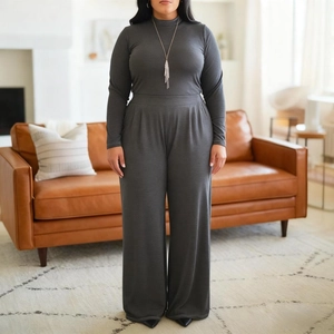 Detail view of charcoal grey high-neck top and wide-leg trousers in soft knit fabric