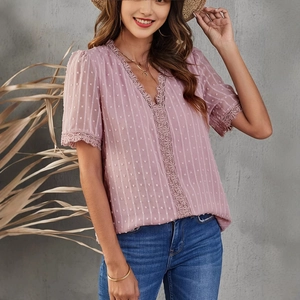 Close-up of pink V-neck chiffon top with delicate lace trim and Swiss dot texture details