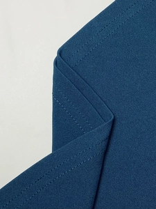 Detail shot of navy blue fabric featuring precise double-needle stitching and texture