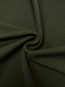 Détail du tissu en maille vert olive foncé avec texture à côtes fines et toucher doux