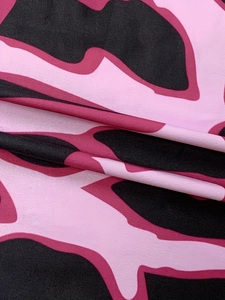 Close-up of pink and black abstract camouflage print on stretchy V-neck dress fabric