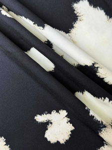 Close-up detail of smooth black and white ink print fabric with soft silk texture