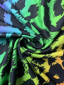 Close-up of vibrant gradient fabric with black geometric patterns and soft draping