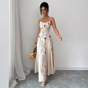 Detailed close-up of a floral maxi dress featuring thin straps and elegant blue patterns