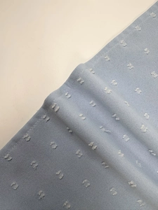 Detailed close-up of light blue clip dot fabric texture and precision stitching quality