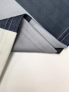 Detailed close-up of premium double-stitched hem on navy and grey wide-leg trousers