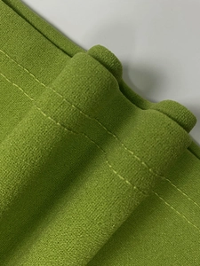 Detailed close-up of fruit green fabric with durable double-row flat stitching craftsmanship
