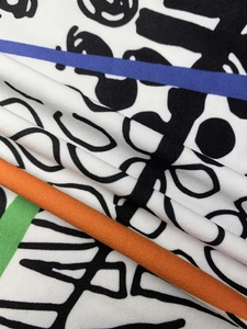 Close-up of lightweight fabric with abstract graffiti print and colorful stripes