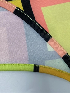 Detail of colorful geometric print fabric with black piping and yellow contrast stitching