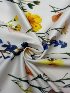 Close-up detail of soft floral print fabric with yellow and blue flowers on white base