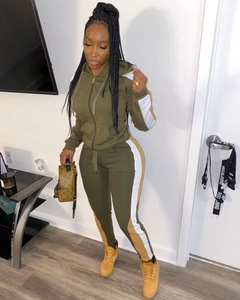 Detail of olive green two-piece tracksuit with contrasting side stripes on sleeves and pants