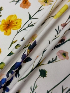 Detailed close-up of floral print fabric with vibrant blossoms and soft pleat texture