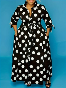 Detail of black polka dot shirt dress featuring long sleeves and waist tie belt