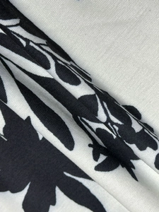 Détail macro de l'imprimé floral noir et blanc sur tissu en maille de coton doux