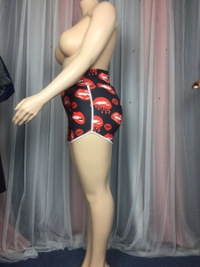 Detail of high waist sports shorts with red lip prints and white side piping trim