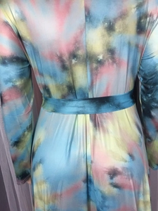 Détail d'une robe longue tie-dye colorée avec manches longues et ceinture assortie