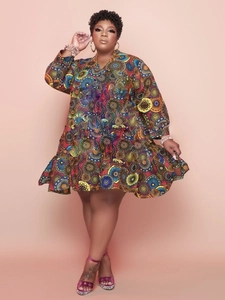 Detail view of colorful geometric print and ruffled hem on a plus size V-neck dress