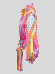 Dettaglio di camicia a righe colorate con maniche a lanterna e fiocco decorativo in vita