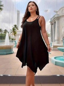 Sleeveless black plus size maxi dress with irregular hem in an outdoor resort setting