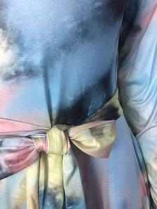 Gros plan sur la robe tie-dye montrant le motif coloré et le nœud à la taille
