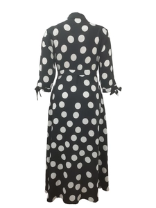 Rear view of long sleeve polka dot dress with waist tie and bow cuff details
