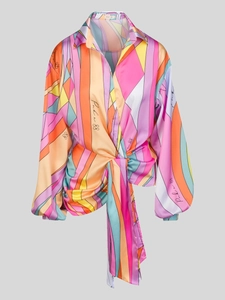 Dettaglio di una camicia a stampa geometrica con nodo frontale e texture setosa