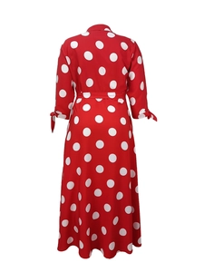 Detail of red polka dot maxi dress featuring waist belt and bow tie cuffs on long sleeves