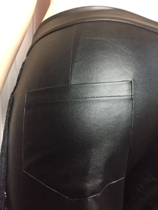 Detailansicht der Gesäßtasche und Fransenverzierung an der schwarzen PU-Lederhose mit hohem Bund