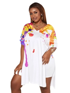 Detail of V-neckline featuring colorful ink splatter print on a loose white tunic top