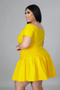 Detail view of bright yellow two-piece set featuring short sleeve top and pleated skirt