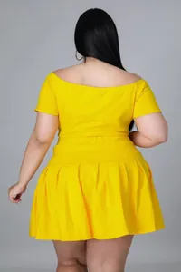 Rear view of a plus-size bright yellow two-piece set featuring a pleated mini skirt