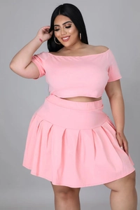 Front detail of pink two-piece set featuring off-shoulder top and pleated mini skirt