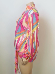 Dettaglio della camicia colorata con stampa geometrica e vita annodata a maniche lunghe