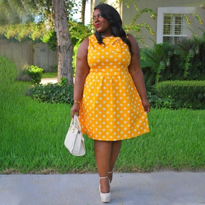 Detailed view of ginger yellow vintage polka dot dress with elegant bow neckline detail