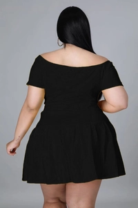 Back view of a black off-shoulder short sleeve top and pleated mini skirt set