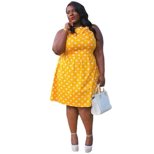 Detail of plus size yellow polka dot dress featuring sleeveless design and bow neckline