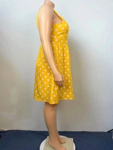 Detail of vintage sleeveless yellow dress with white polka dots and a waist tie design