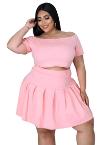 Detail of light pink two-piece set featuring off-shoulder top and pleated mini skirt