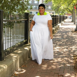 Detail of white high-waist pleated maxi dress with side pockets and dynamic movement
