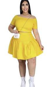 Detailed view of women plus size two piece set with yellow off-shoulder top and pleated skirt